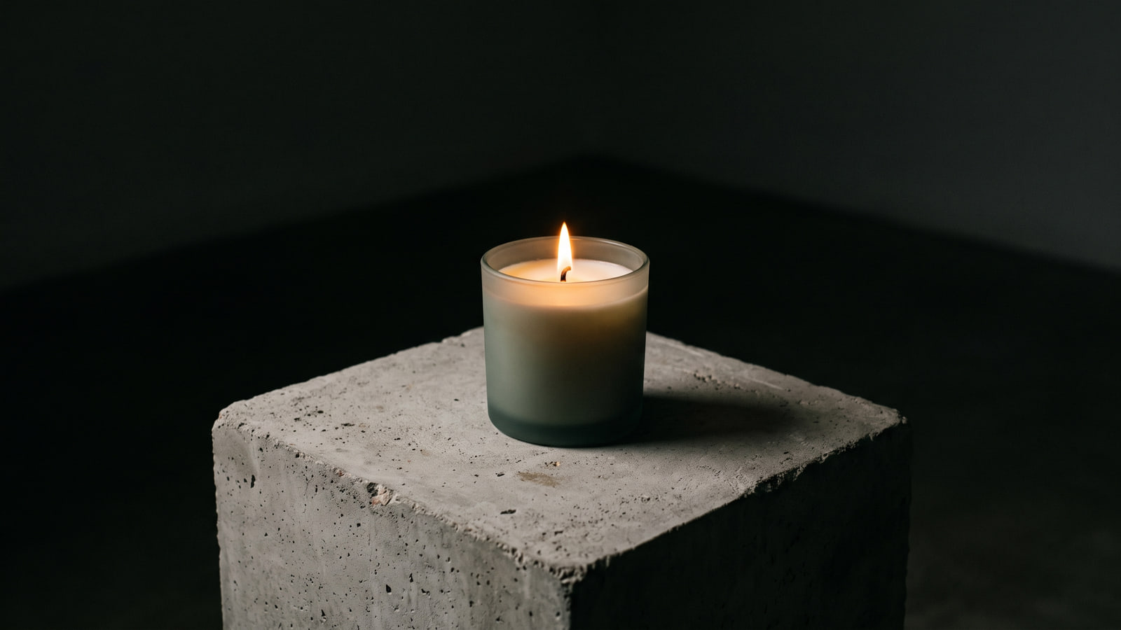Byredo style tinted glass candle in a minimalist dark interior